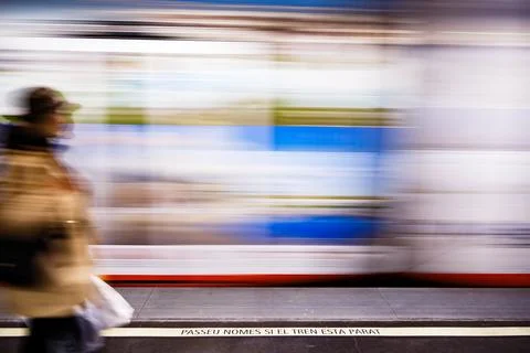 The moving train with a warning sign and blurred woman Stock Photos