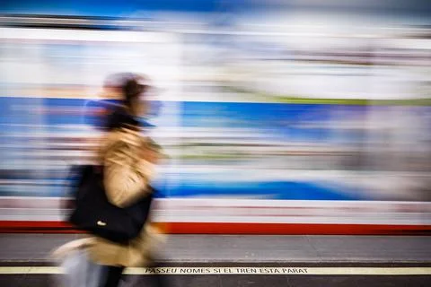 The moving train with a warning sign and blurred woman Stock Photos