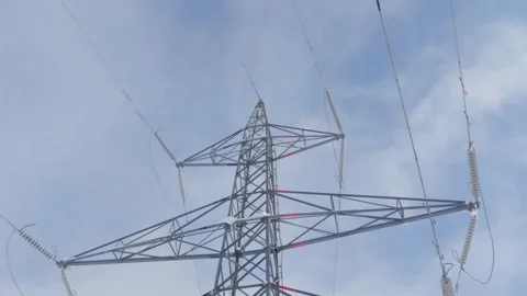 Moving under high voltage electricity cables on sunny winter day Stock Footage 245976597