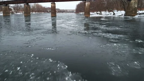 Moving Under Railroad Bridge Close to Icy River Surface FLY IN Stock Footage 102587335