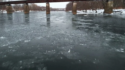 Moving Under Railroad Bridge Close to Icy River Surface FLY IN SLOW MOTION Stock Footage 102587422