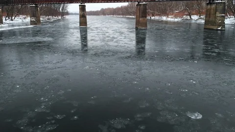 Moving Under Railroad Bridge Over Icy River FLY IN Stock Footage 102587307