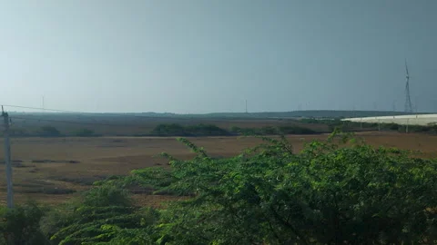 Moving Vehicle View of Wind Farm and Power Infrastructure in Dry Landscape Stock Footage 336198017