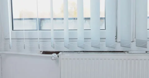 Moving vertical blinds, hung in the room by the window. Central heating. Stock Footage 228689024