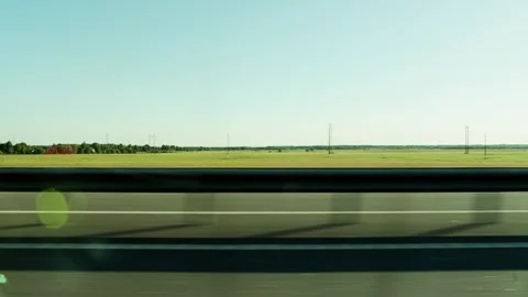 Moving view from car window along highway, wide green fields stretching towards Stock Footage 339864648
