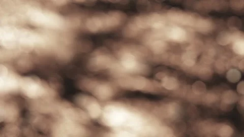 Moving water creates a bokeh sparkling abstract effect with beige light colored Stock Footage 339733224