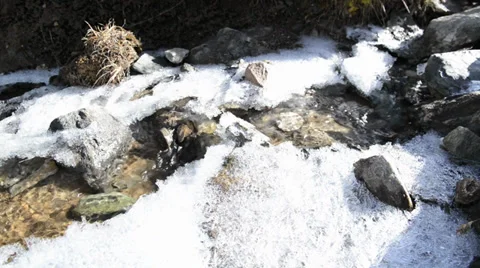 The moving water through the pristine ice and snow of winter Stock Footage 32309903