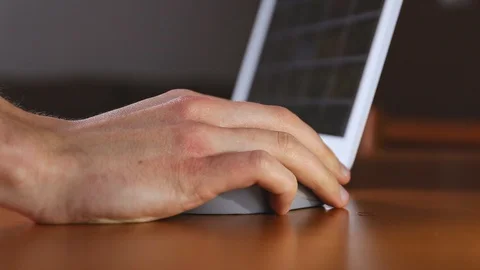 Moving a wireless computer mouse while surfing on the internet on a notebook Stock Footage 129457348