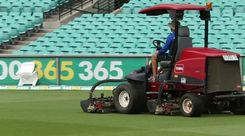 Mower is mowing the cricket grounds before the game Stock Footage 52335441