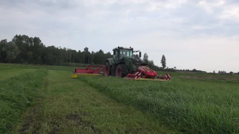 Mower working in the field on a cloudy day Stock Footage 239563414