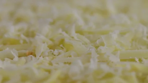 Mozarella Cheese tumbles in slow motion onto a slowly spinning pizza. Stock Footage 72540626