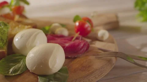 Mozzarella and pesto cherry tomatoes on a cutting board Stock Footage 58586740