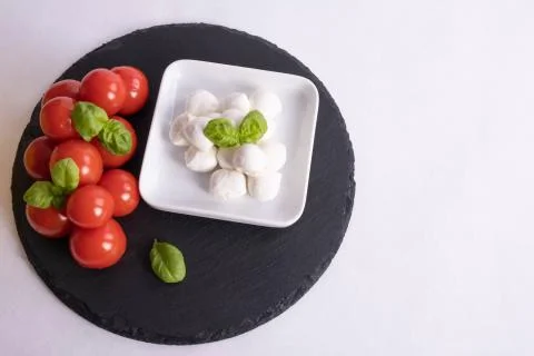 Mozzarella and tomatoes on a table Stock Photos