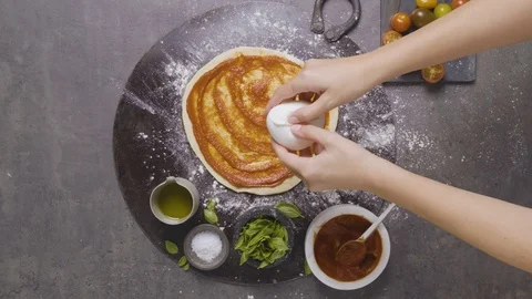 Mozzarella being added to a pizza 스톡 동영상 124584753