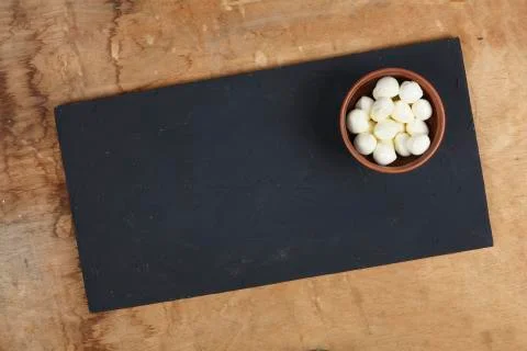 Mozzarella in a bowl on a stone table Fotos de archivo