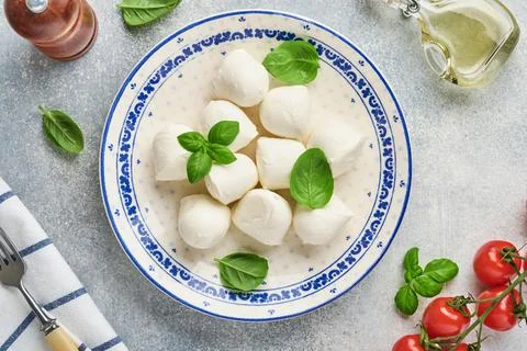 Mozzarella cheese with basil in white ceramic plate, tomato cherry olive oil  Stock Photos