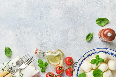 Mozzarella cheese with basil in white ceramic plate, tomato cherry olive oil  Stock Photos