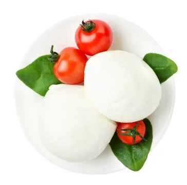 Mozzarella, cherry tomato and spinach leaves in a plate close-up on a white b Stock Photos