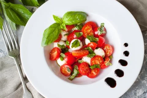Mozzarella, cherry tomatoes and basil salad Stock Photos