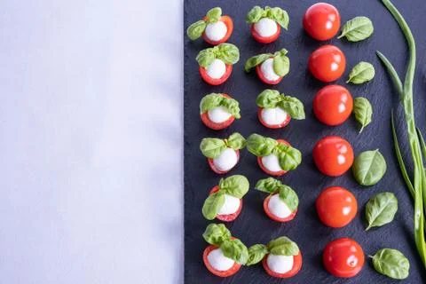 Mozzarella in red tomatoes on a black tile Stock Photos