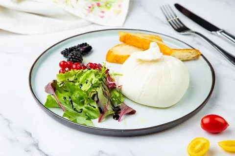 Mozzarella with spinach, cherry tomatoes, wild berries and bread in a round Stock Photos