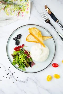 Mozzarella with spinach, cherry tomatoes, wild berries and bread in a round Stock Photos