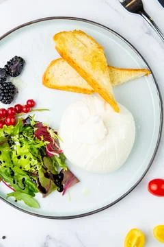 Mozzarella with spinach, cherry tomatoes, wild berries and bread in a round Stock Photos