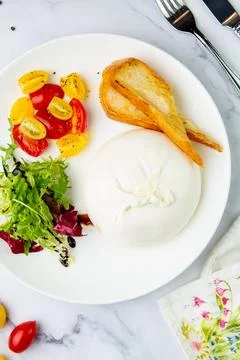 Mozzarella with spinach, cherry tomatoes, wild berries and bread in a round Stock Photos