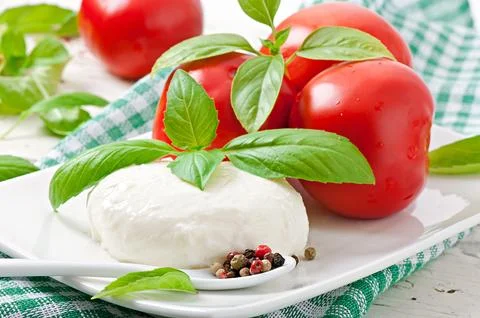 Mozzarella, tomatoes and fresh basil leaves Stock Photos