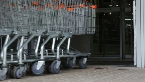 Mployee worker push Row of shopping carts to entrance of supermarket Video stock 78188343