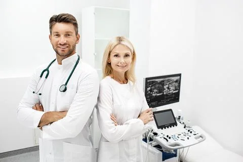 Mr and Mrs doctors standing at modern clinic. Group of doctors, teamwork. Por Stock Photos