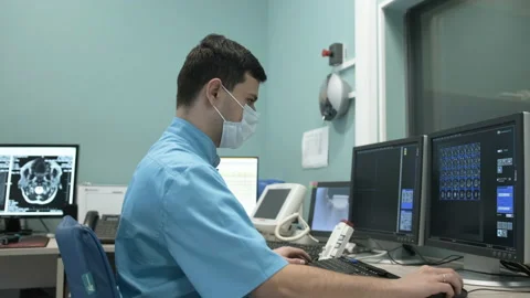 MRI operator makes the procedure for scanning the patient's brain Stock Footage 163367582