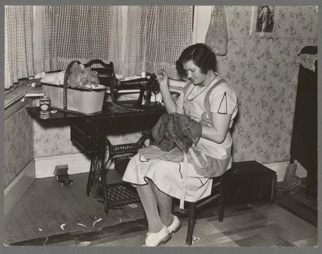 Mrs. Carl Thorson patching clothes in home, Crosby, North Dakota. 1937. Ph... Stock Photos