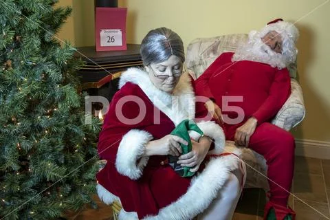Mrs. Claus massaging Santa's tired feet Stock Photos