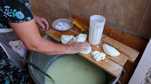 Mrs Sofia cuts Halloumi chesse in Sofia And Andreas Traditional House in Lety Stock Footage 232928049