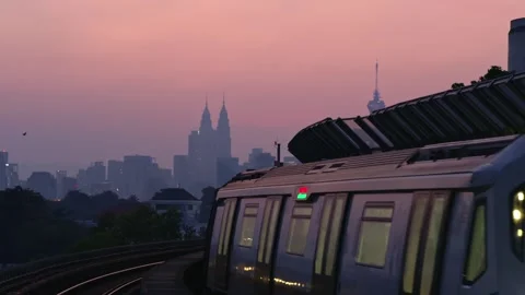 MRT Train passing through station, KLCC Twin towers and KL Tower in the Stock Footage 345641068