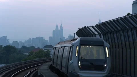 MRT Trains passing through train station, KLCC Twin towers and KL Tower in the Stock Footage 345641154