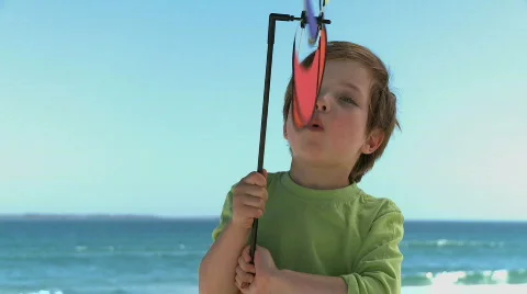 MS OF A BOY BLOWING ON A PIN WHEEL Stock Footage 542423