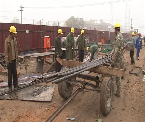 MS construction workers in hard hats loading cart with iron bars Video stock 86744281