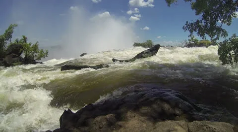 MS fast flowing river Spray from Victoria Falls in background Stock Footage 22873040