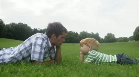 MS Father and son lying on grass face to face Video stock 11340629