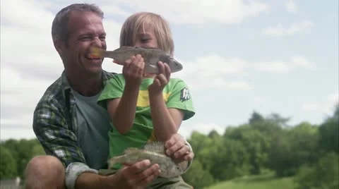 MS Father and son playing with catch of fish Video stock 11347862