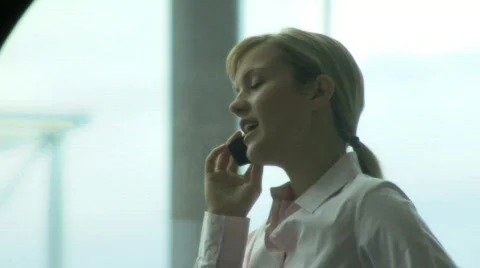 MS FEMALE IN FRONT OF WINDOW TALKING ON PHONE Stock Footage 541062