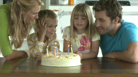 MS OF A GIRL BLOWING OUT CANDLES ON A BIRTHDAY CAKE Stock Footage
