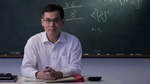MS Man sitting at desk taking off glasses, looking at camera Stock Footage 69937324