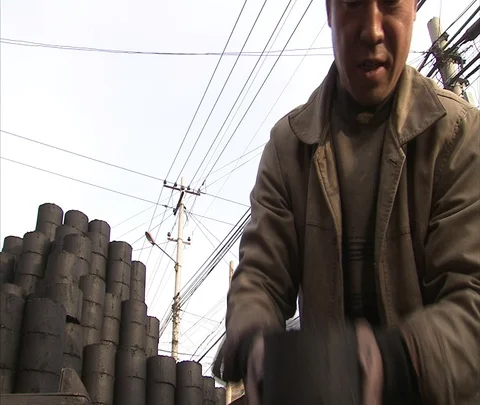 MS man unloading coal ash bricks from truck and stacking them on ground Stock Footage 86745410