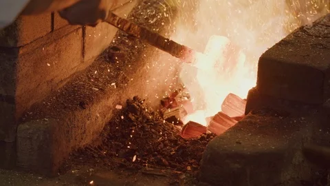 MS Master Swordsmith pulling out white hot metal from forge to check temperature Stock Footage 125429009