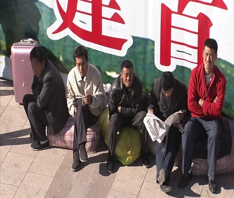 MS men sitting on luggage In front of Beijing Railway Station Stock-Footage 86745151