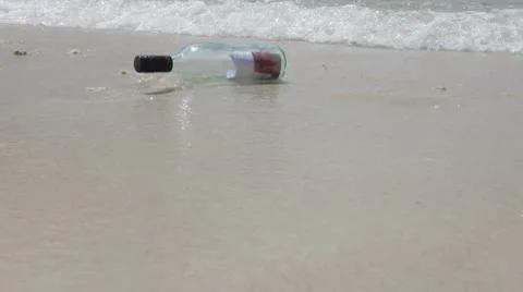 MS A message in a bottle on the shore of a beach Stock Footage 10703260