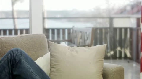 MS PAN Man sitting on sofa drinking coffee Stock Footage 11291254